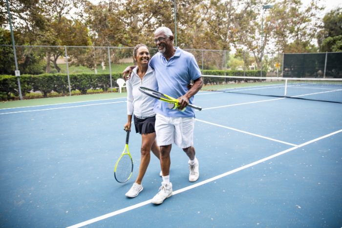 happy old couple playing tennis