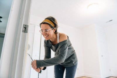 a happy lady painting their room