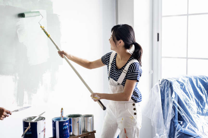A woman painting the wall white