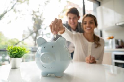 couple saving coins into piggy bank