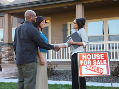 couples shakes hands with real estate agent